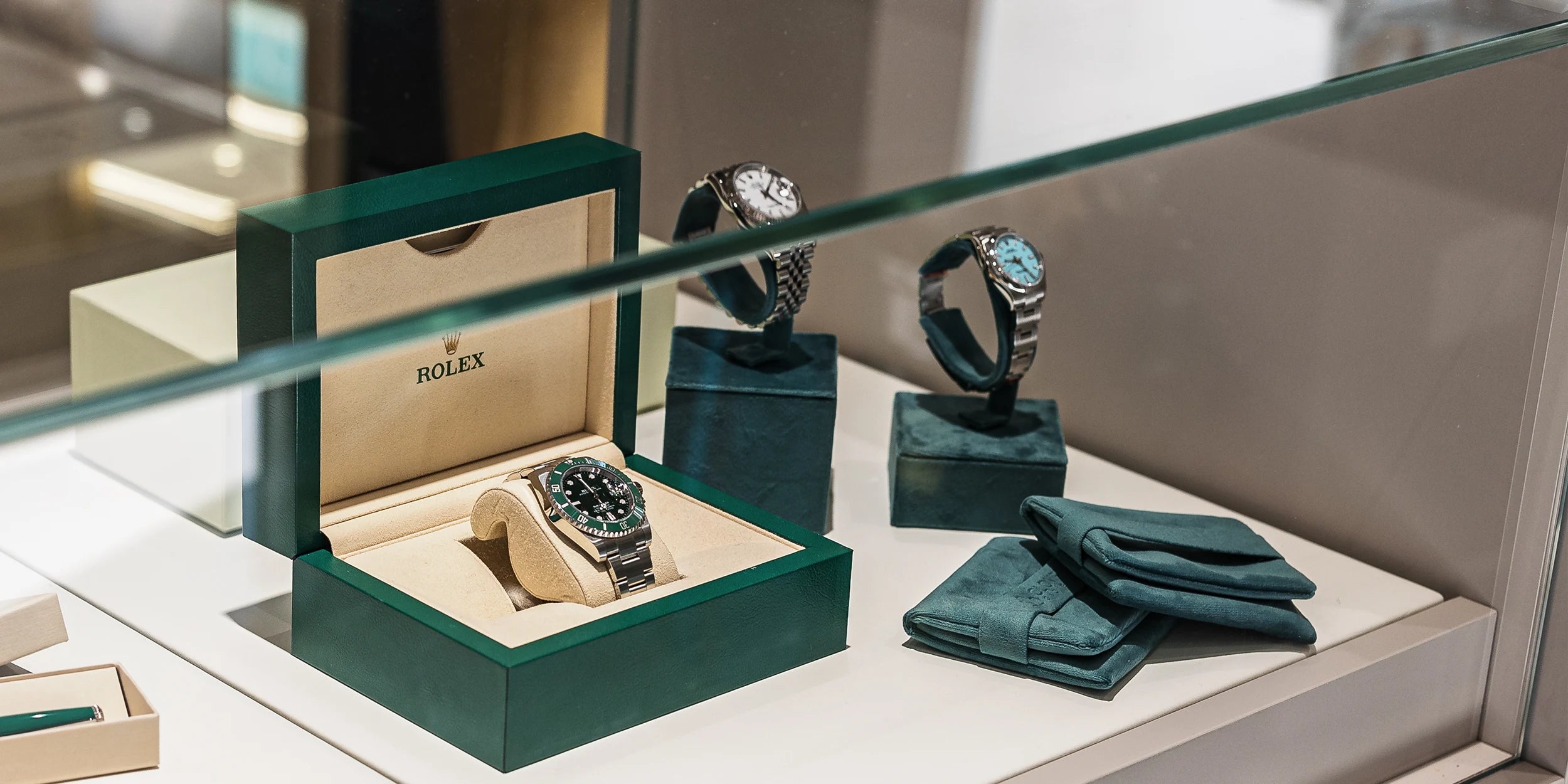 Esposizione Rolex in vetrina in boutique Clover Gioielli, con il proprio cofanetto in velluto verde