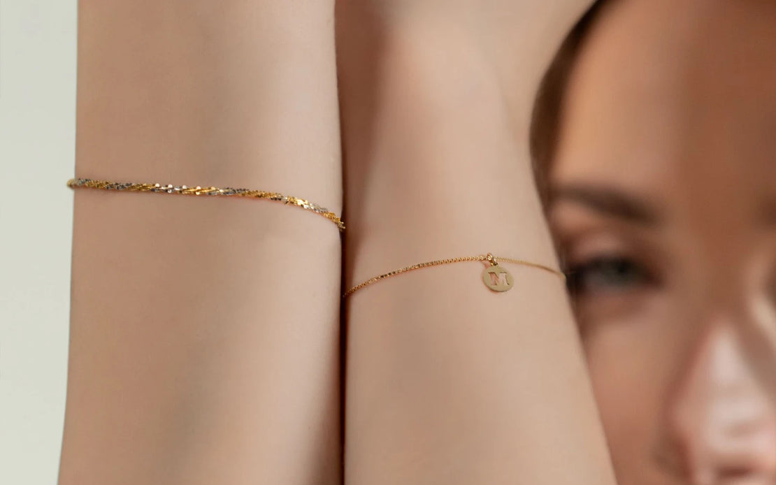 Applicazione di un bracciale saldato in filo d’oro con un charm personalizzato, servizio offerto da Clover Gioielli