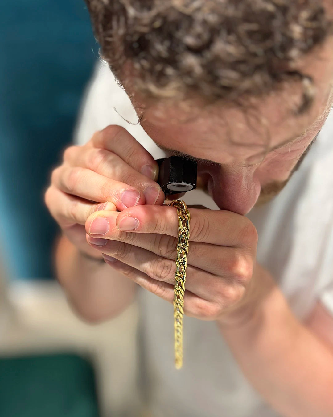 Esperto di Clover Gioielli mentre esamina un gioiello con lente nel negozio compro oro di Prato