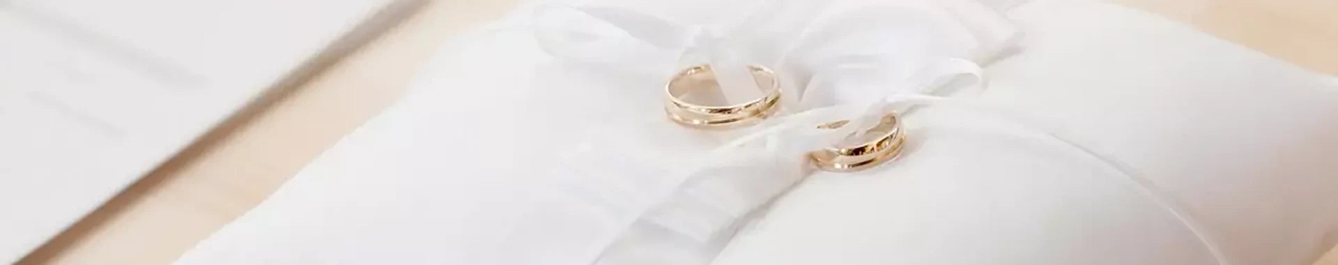 Gioielli da matrimonio su cuscinetto bianco delle fedi