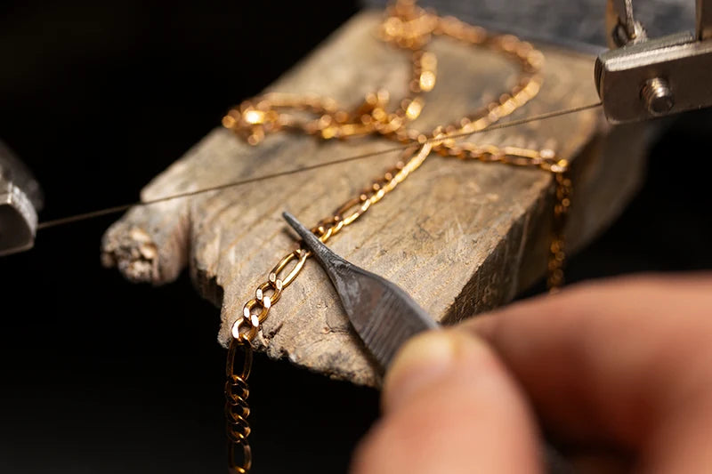 Tecnico orafo che effettua una riparazione su un ciondolo presso Clover Gioielli