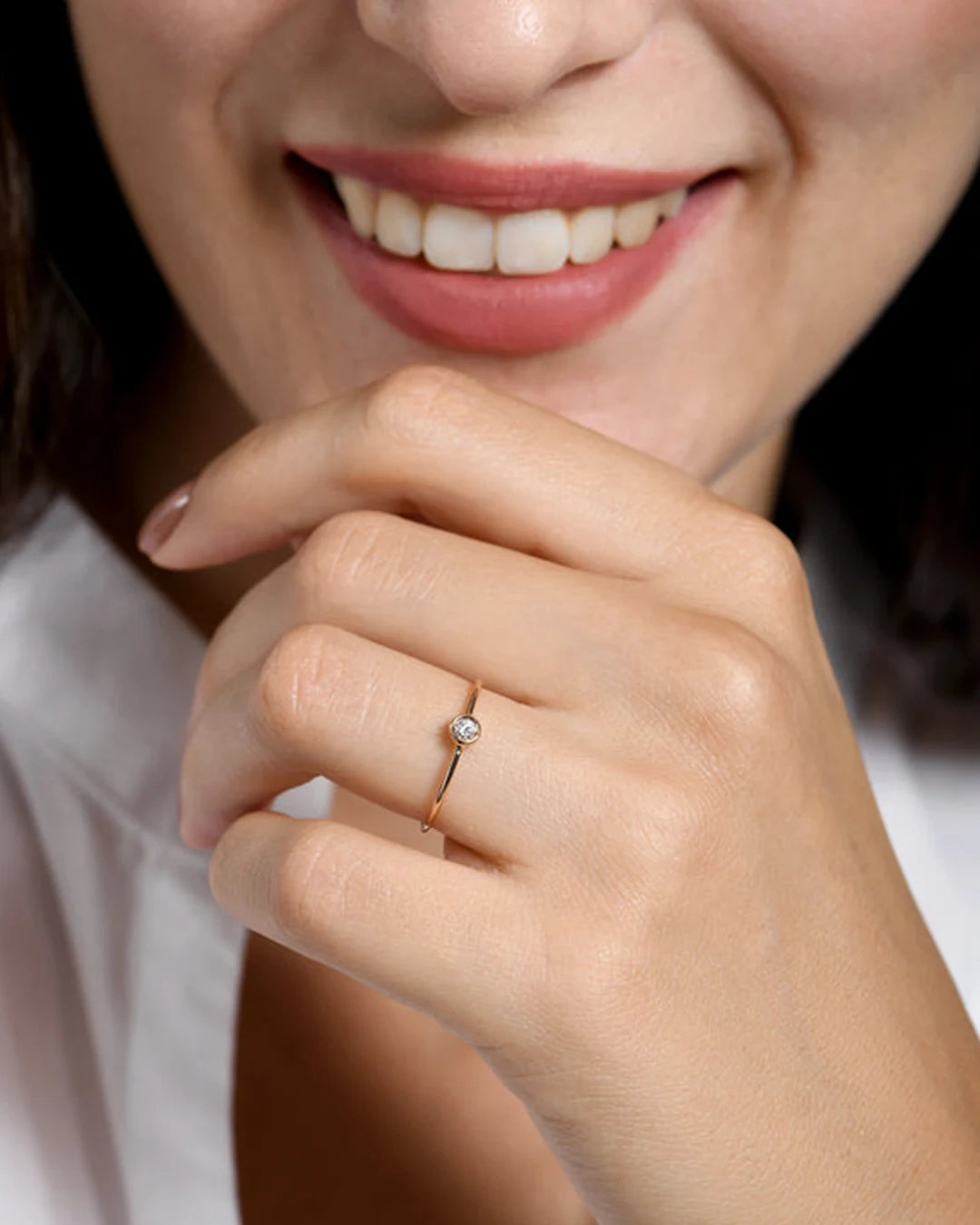 Donna che sorride con al dito un anello presente nello shop di Clover Gioielli