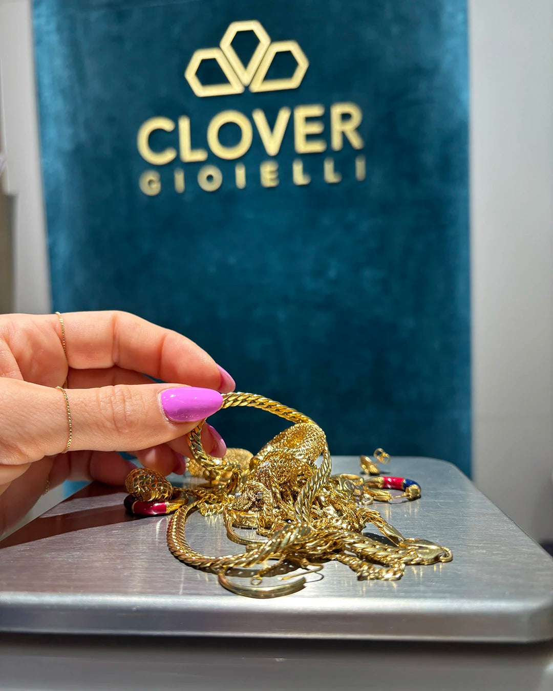 Mano di donna con gioielli e oggetti in oro da valutare