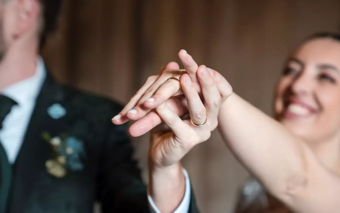 Gioielli da matrimonio di due sposi con la fede al dito